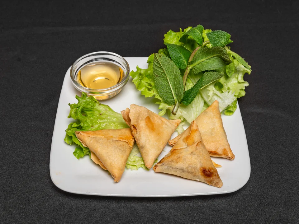 Quatre samoussas dorés avec salade et menthe