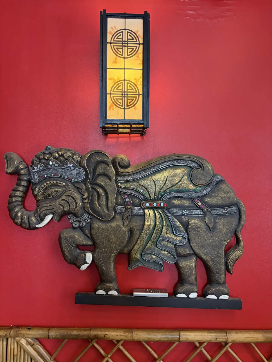 Éléphant sculpté doré sous une lanterne